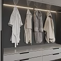 Soft White And Light Gray Robes Hanging In Modern Wardrobe With LED Lights And Drawers