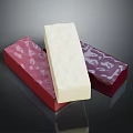 White Block Cheese Displayed On Red Shiny Wrappers Against Dark Background