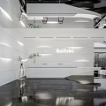 Modern Front Desk Reception Area With BaiTube Signage White Walls Green Plants And Black Flooring