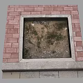 Square Area With Red Brick Border And Dirt Weeds Inside On Stone Base