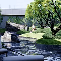 Landscaped Courtyard Garden with Large Rocks Flowing Water Feature Green Trees and Trimmed Shrubs