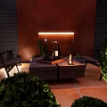 Cozy Courtyard Garden With Brick Wall Wooden Chairs Fire Pit And Lush Greenery