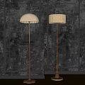 Two Classic Wooden Floor Lamps with Beige Shades Against Dark Textured Wall