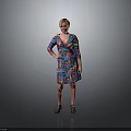 Woman in Colorful Floral Dress Standing with One Hand on Hip Against Gray Background