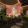 Outdoor Camping Style Restaurant Interior with String Lights Green Plants Projection Screen Wooden Tables and Stone Path