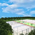 Outdoor Sports Facility With Basketball Courts Green Surfaces Fences Trees And Blue Sky