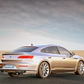 Silver Volkswagen Sedan Driving on Desert Road with Clear Blue Sky