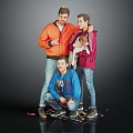 Group of Three Men With Dog Posing In Orange Red Blue Jackets On Grey Background