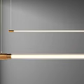 Long Linear Pendant Light With Golden Metallic Base Illuminated Tube Hanging In Modern Gray Interior