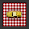 Fresh Cooked Corn Cob With Butter On Top Placed On Red And White Checkered Cloth