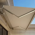Outdoor Retractable Awning With Beige Fabric And Metal Frame On Building Exterior