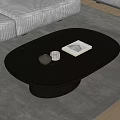 Modern Black Oval Coffee Table With Gray Sofa On Rug And Decorative Book