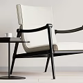 Modern Accent Chair With Black Frame Beige Upholstery And Side Table With White Cup Books