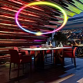 Colorful Neon Ring Decorated Bar Interior With City Night View Red Chairs And Dining Table