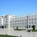 Modern White School Building Exterior With Plaza Greenery Trees And Clear Blue Sky