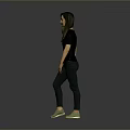 Woman in Black Top and Dark Pants with Green Shoes Standing Against Gray Background