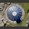 Iconic White Spiked Building With Blue Dome In Circular Plaza And Green Surroundings