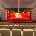 Formal Auditorium Interior With Red Stage Beige Seats And Stage Lights