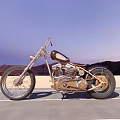 Vintage Motorcycle With Metallic Finish And Leather Seat On Open Road Against Mountain Sunset Sky