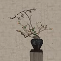 Black Vase with Branches Orange Fruits and Green Leaves on Square Base Against Beige Wall