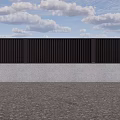 Black Vertical Slats Fence With Gray Wall Black Door On Gravel Ground Under Blue Sky