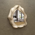 Irregular Curved Edge Mirror With Metallic Finish Reflecting Bedroom Interior On Gray Wall