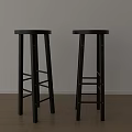 Two Black Bar Stools With Round Seats Ladder Style Legs White Wall Wooden Floor