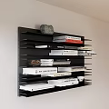 Stylish Black Layered Wall Shelf Displaying Books Magazines and Decorative Stone