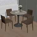 Round Dining Table with Four Brown Chairs and Vase Flowers Book Cup in Light Room