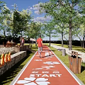 Scenic Municipal Road With Red Path Runners Distance Markers Trees Benches And Trash Bins