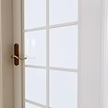 Sleek White Hinged Door With Glass Panes And Brass Handle Design
