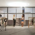 Spacious Public Office Space Featuring People Conversing Clothing Racks And Photography Gear
