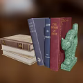 Colorful Stacked Books With Green Cat Shaped Bookend And Various Covers