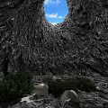 Natural Cave Landscape With Circular Opening Showing Blue Sky And Green Plants