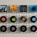 Decorative Wall Hangings With Square Prints And Round Vinyl Records In Clear Frames On Wall