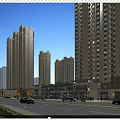 High rise buildings surrounding vibrant commercial street with shops cars and pedestrians in evening