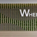 Natural Green Plant Background Wall With Wooden Stripes And Brand Logo WHEEL