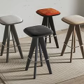 Modern Bar Stools With Various Colored Upholstered Seats And Wooden Legs