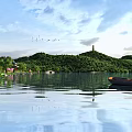 Stunning Lakeside Natural Landscape With Lush Green Hills Calm Water Ancient Pagoda And Flying Birds