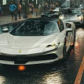 White Ferrari Sports Car On Wet City Street With Sleek Black Wheels