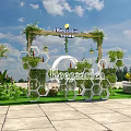 Outdoor Decorated Arch With Green Plants Bloomville Sign And White Circular Decor On Lawn