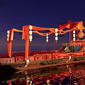 Traditional Wooden Boat With Red Fabrics Lanterns And Stairs Floating On Night Sea With Reflections