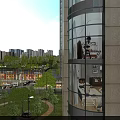 Modern Garden Landscape with Trees Lawns Street Lamps near Glass Wall High Rise Building
