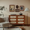 Wooden Decorative Cabinet With Carved Drawers And Framed Artworks Near Armchair And Table Lamp