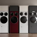 Modern Washing Machines in White Red and Gray Arranged Against Dark Wall on Wooden Floor