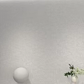 Gray Background Wall with White Spherical Object and Green Plants in White Vase