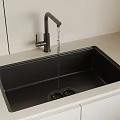 Black Kitchen Sink With Running Water And Matte Black Faucet On Light Countertop