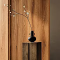 Minimalist Black Vase With White Flowers On Carved Wooden Pedestal Against Wooden Wall