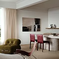 Open Living and Dining Area With Large Windows Black Sofa Red Armchair Fireplace Round Mirror