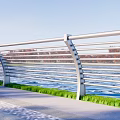 Modern Metal Fence With Horizontal Bars Along Waterfront Green Grass And Blue Sky